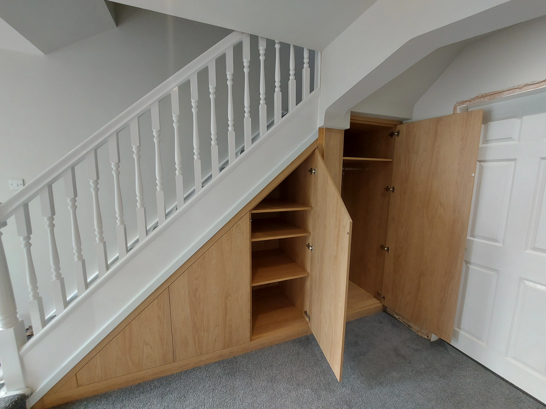 Large oak under stairs storage with touch open mechanisms open