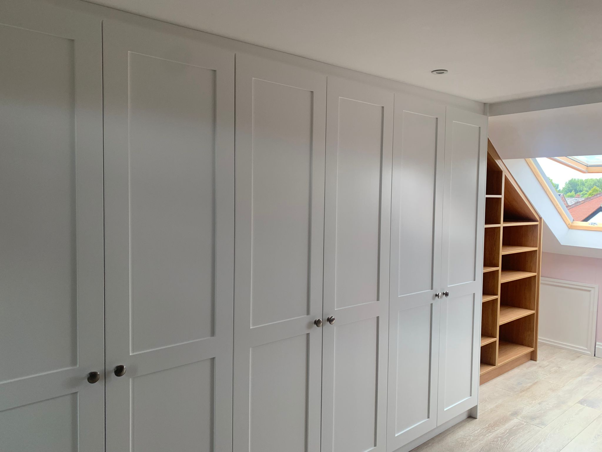 Wardrobe in a loft with an angled bookcase